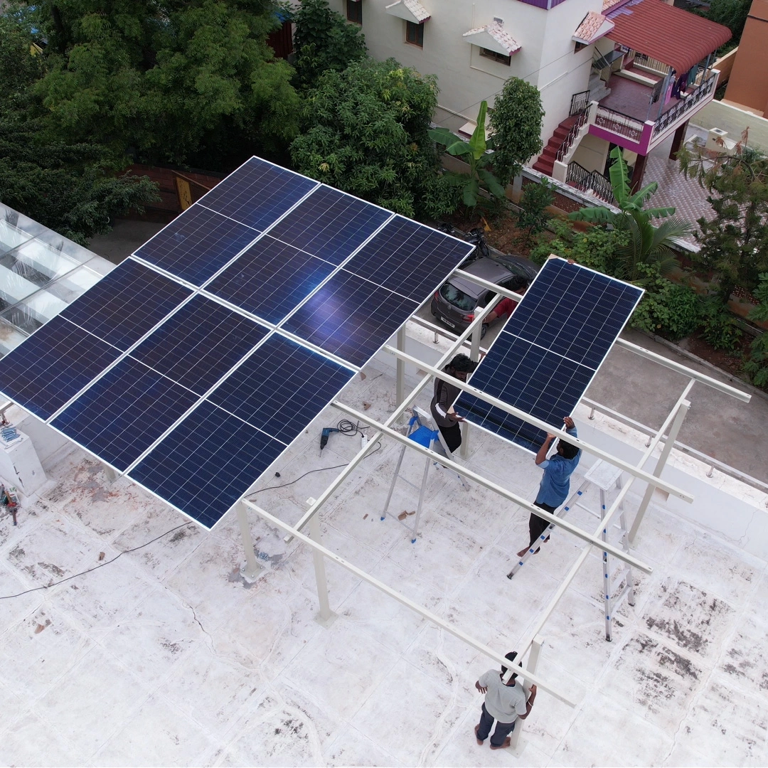 Technicians mounting solar panels on roof mounting structure